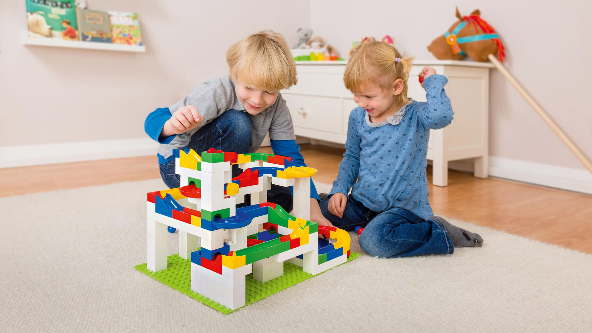 Hubelino - Spielende Kinder mit Konstruktionssteinen (wie Lego)